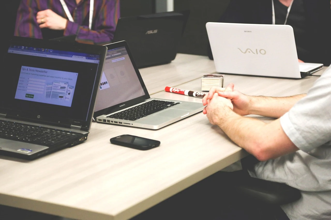 Équipe en réunion avec ordinateurs pour valider les actions d’une automatisation IA